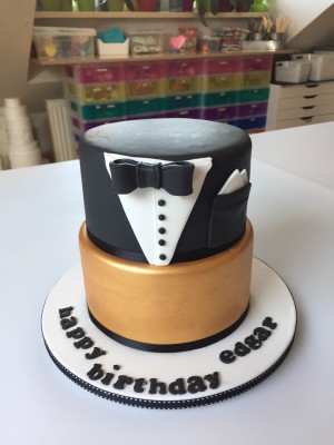 Feesttaarten - Stapeltaart smoking met gouden ondertaart en vlinderstrik